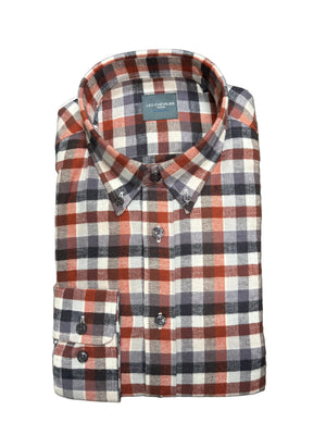A folded long-sleeve plaid button-down shirt by Leo Chevalier, featuring a red, white, and navy check pattern, laid flat on a textured green carpet.