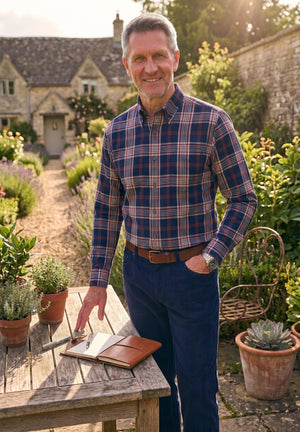 A folded men's button-down shirt by Vivella, featuring a blue, beige, and white plaid pattern, displayed on a clean white background.